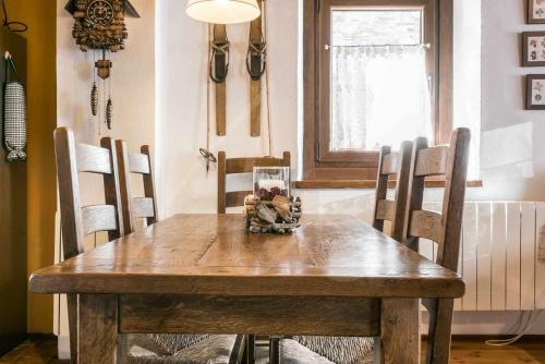 a wooden table and chairs in a dining room at Casa Nere by SeaMount Rentals in Salardú