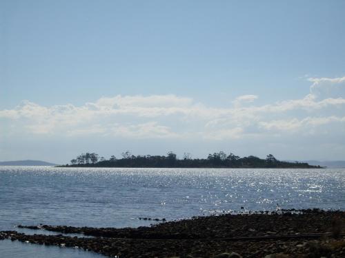 uma ilha no meio de um grande corpo de água em Four Seasons Waterfront Villas em Taranna