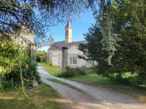 an old church with a tower and a dirt road at Gite de la Chapelle - Circuit des 24 heures - ARNAGE - 10 personnes in Les Loges