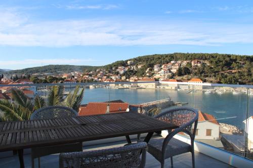 ein Balkon mit Tisch und Stühlen und einem Gewässer in der Unterkunft Apartments Mara in Jelsa