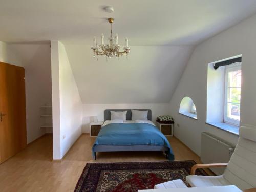 a bedroom with a blue bed and a chandelier at Schlossapartments Wolfsberg in Wolfsberg
