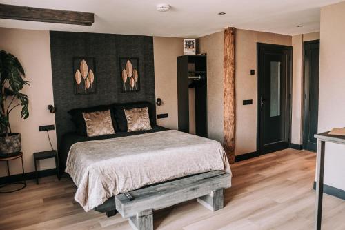 sypialnia z łóżkiem z czarnym zagłówkiem w obiekcie Bed and Breakfast de WoerdT w mieście Altforst