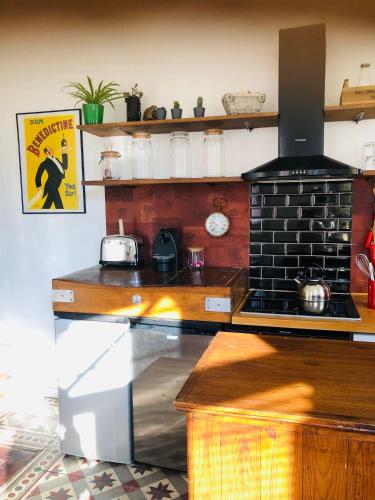 une cuisine avec une cuisinière et un comptoir dans l'établissement Charmante maison de pêcheurs plein centre à 5min du port, à Fécamp