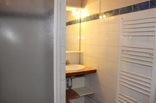 une salle de bain blanche avec un lavabo et un miroir dans l'établissement Face aux Thermes, à Rochefort