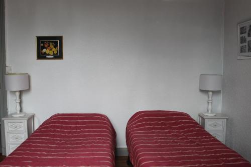 - une chambre avec 2 lits et 2 lampes murales dans l'établissement Face aux Thermes, à Rochefort