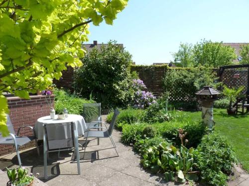 a patio with a table and chairs in a garden at Ferienwohnung "Herrmi" Objekt ID 12050-5 in Waren