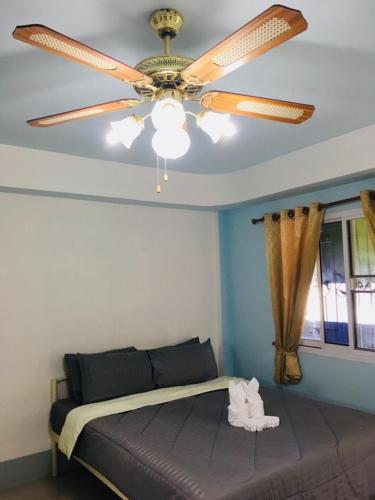 a bedroom with a ceiling fan and a bed at Subrangsee Apartment in Chiang Rai