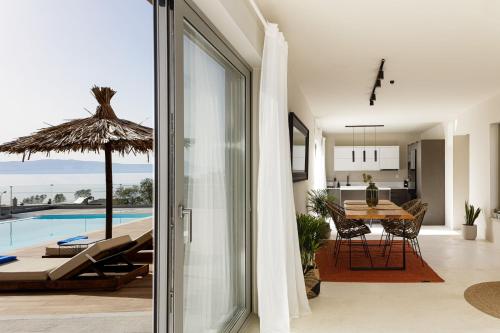 a living room with a view of a pool and a house at Aristotelis Residence in Petres
