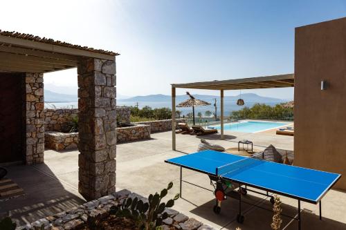 a blue ping pong table on a patio next to a pool at Aristotelis Residence in Petres