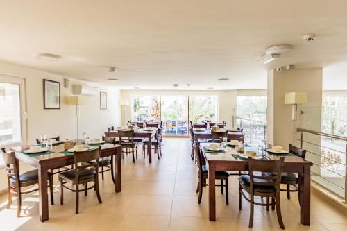 a restaurant with wooden tables and chairs and a balcony at The Seventh Star Hotel Suites in Amman