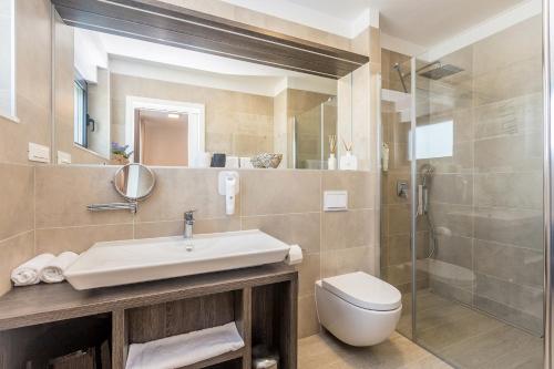 a bathroom with a sink and a toilet and a shower at Villa Poseidon Rova by EL-PI TOURS in Malinska