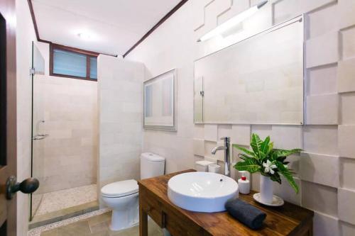 e bagno con lavandino, servizi igienici e doccia. di Elysia Nongsa 57 Batam Luxury Villa a Nongsa