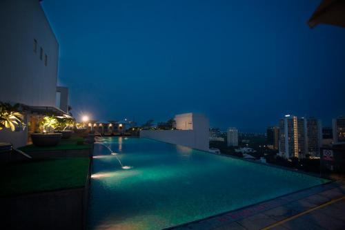 a swimming pool on the roof of a building at night at Somerset Greenways Chennai in Chennai