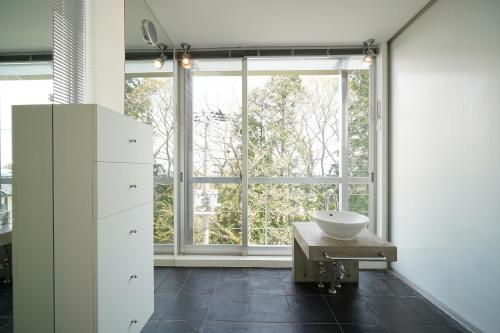 a bathroom with a sink and a large window at ファミーユ大室Ⅱ in Futo