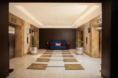 a hallway with a lobby with a blue couch at Somerset Greenways Chennai in Chennai