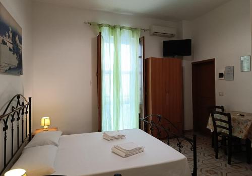 ノートにあるCasa Il Pescoのベッド1台、テーブル、窓が備わる客室です。