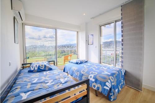 une chambre avec deux lits et une grande fenêtre dans l'établissement Duplex Avec Rooftop Et Vue Mer Panoramique - Riou De L'argentière, à Mandelieu-la-Napoule