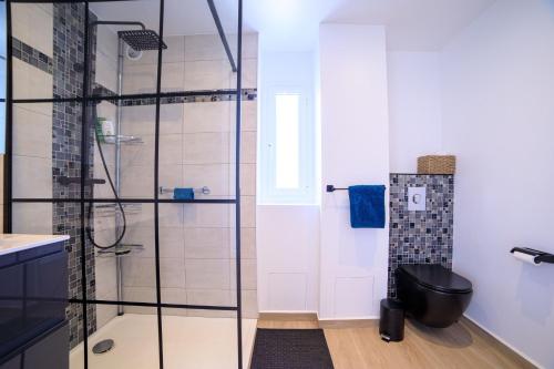 La salle de bains est pourvue d'une douche et de toilettes noires. dans l'établissement Duplex Avec Rooftop Et Vue Mer Panoramique - Riou De L'argentière, à Mandelieu-la-Napoule