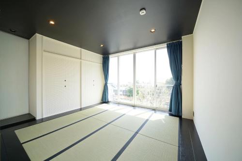 an empty room with a large window and a door at ファミーユ大室Ⅱ in Futo