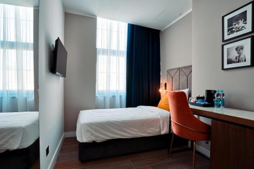 a bedroom with a bed and a desk with a chair at Cinematique in Mosta