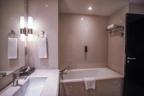 a bathroom with a bath tub and a sink at Somerset Greenways Chennai in Chennai