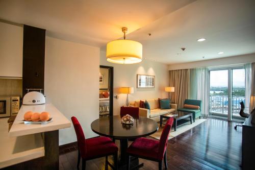 a living room with a table and chairs and a couch at Somerset Greenways Chennai in Chennai