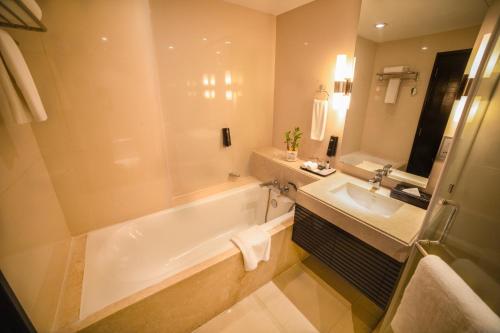 a bathroom with a tub and a sink at Somerset Greenways Chennai in Chennai