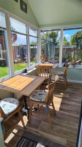 een eetkamer met een houten tafel en stoelen bij Morland in Burrowbridge