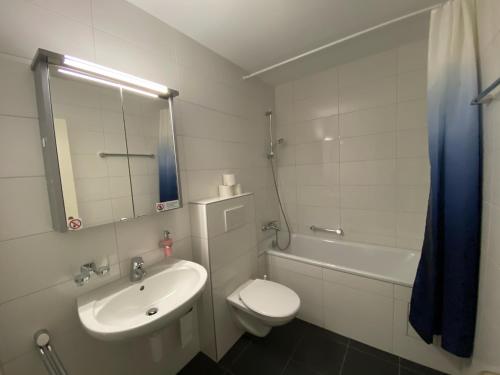 a bathroom with a sink and a toilet and a mirror at Galaxy Apartments Lucerne in Luzern