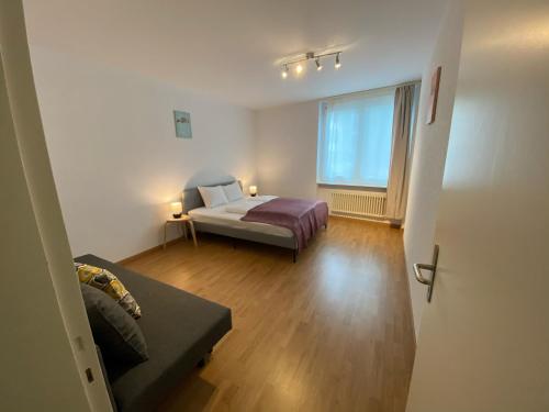 a room with a bed and a couch and a window at Galaxy Apartments Lucerne in Luzern