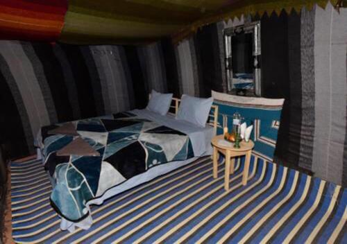 a bedroom with a bed and a side table at Mhamid polski desert camp in El Gouera