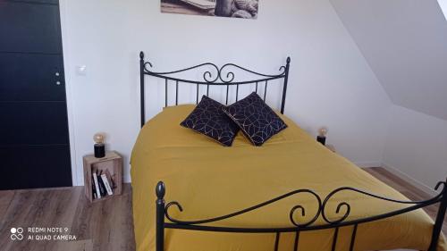 sypialnia z żółtym łóżkiem z 2 poduszkami w obiekcie La BELLA 12 - Chambre d'hôtes SDB Privative w mieście Bordeaux-Saint-Clair