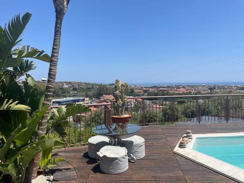 a patio with a table and a swimming pool at Villa Carly Taormina apartment with private pool in Trappitello