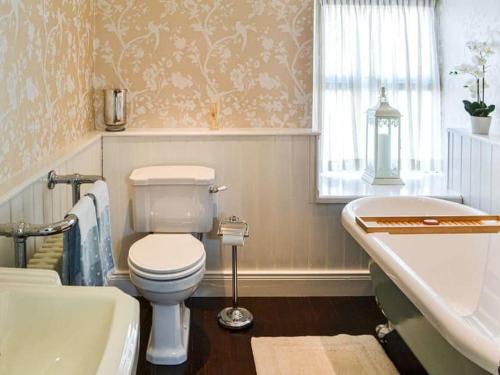 a bathroom with a toilet and a tub and a sink at Milburn House in Bellingham