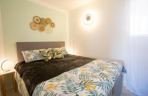 ein Schlafzimmer mit einem Bett mit einer Bettdecke darauf in der Unterkunft LA VIE EST BELLE - refait à neuf in Gassin