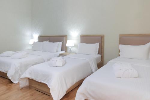 a room with three beds with white sheets at HUMSON BULOQ SANATORIUM in Khumson