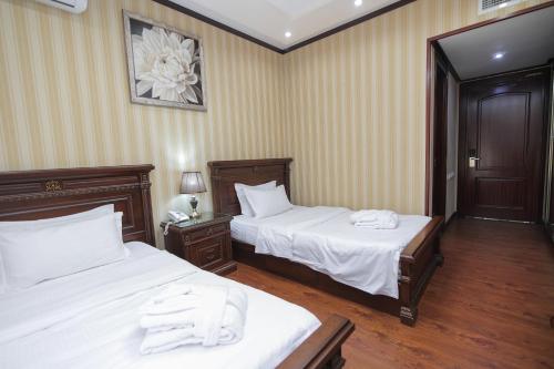 a hotel room with two beds with white sheets at HUMSON BULOQ SANATORIUM in Khumson