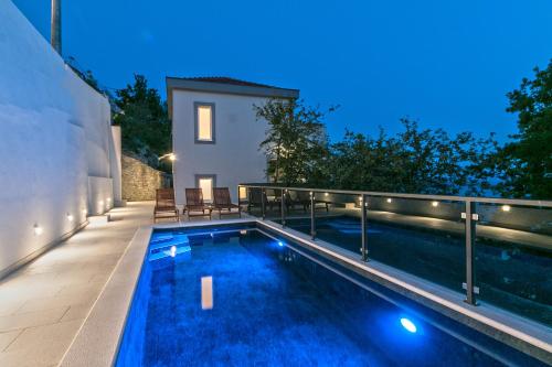 a swimming pool in the backyard of a house at night at Villa Marinkica in Brela