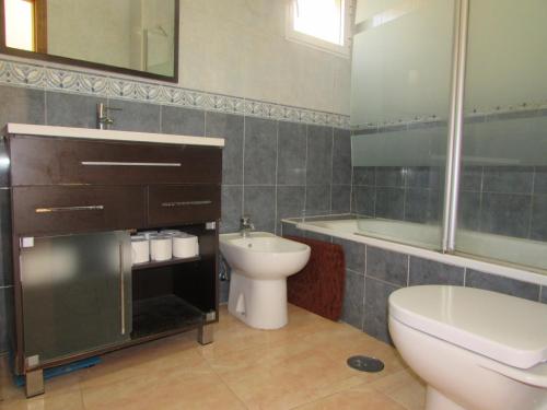 La salle de bains est pourvue d'un lavabo, de toilettes et d'une baignoire. dans l'établissement VERA BIG FAMILY HOME, à Vera