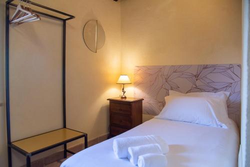 a bedroom with a white bed and a lamp at Relais Borgo Campello in Campello sul Clitunno