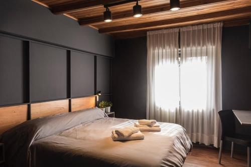 1 dormitorio con 1 cama con 2 toallas en Luma Boutique Hotel en San Carlos de Bariloche
