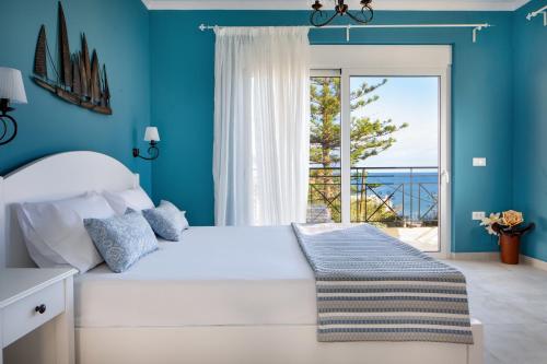 1 dormitorio con cama blanca y vistas al océano en Evi Boutique Rooms, en Galatás