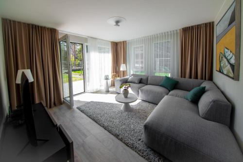 ein Wohnzimmer mit einem Sofa und einem Tisch in der Unterkunft COME2rest - Smilga in Juodkrantė