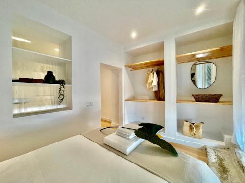 Cette chambre blanche comprend un lit et un miroir. dans l'établissement Casa da Lapa, à Lisbonne