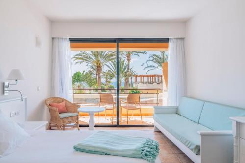 a bedroom with a couch and a view of a patio at Iberostar Waves Playa Gaviotas All Inclusive in Morro del Jable
