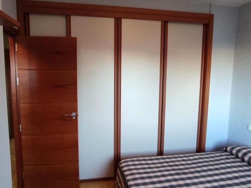 sypialnia z łóżkiem i drewnianą szafą w obiekcie Calle Ancla Isla Cristina w mieście Isla Cristina