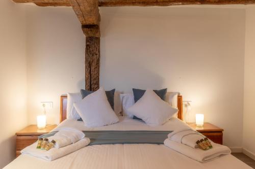1 dormitorio con 1 cama con almohadas blancas en La Casita del pescador By Kabia Gestión, en Bermeo