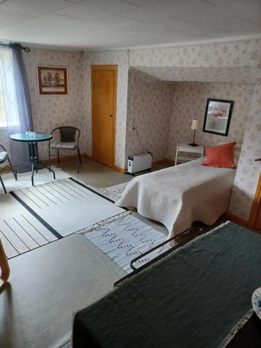 a bedroom with a large bed and a room with a table at Kopparhyttan1 in Valdemarsvik