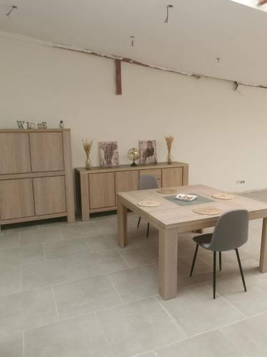 a room with a table and chairs and cabinets at Le caillou Blanc in Charleroi