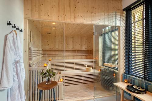 a bathroom with a tub and a shower with a table at Grootbos Private Nature Reserve in Gansbaai